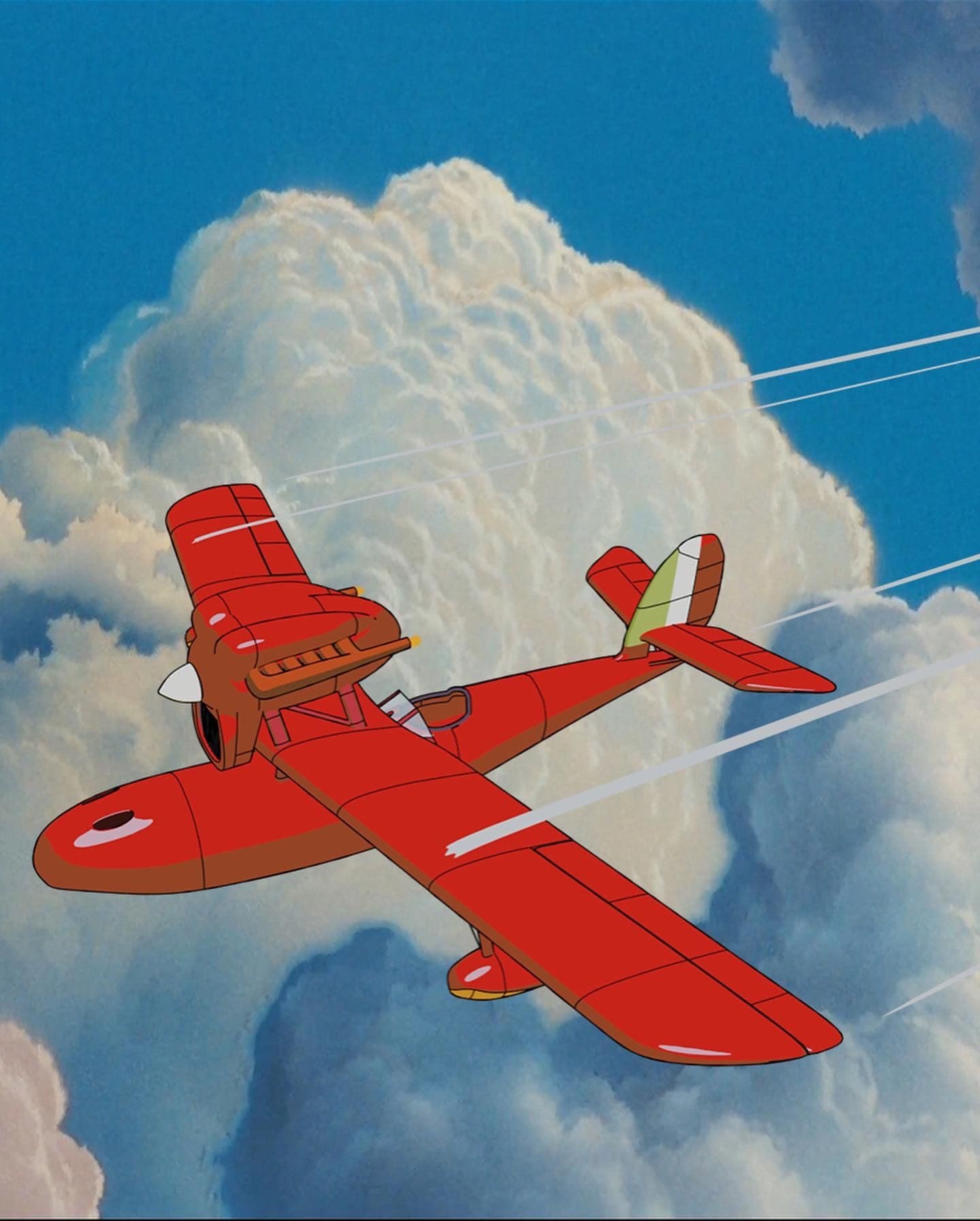 A red, vintage seaplane flies through fluffy white clouds under a blue sky.